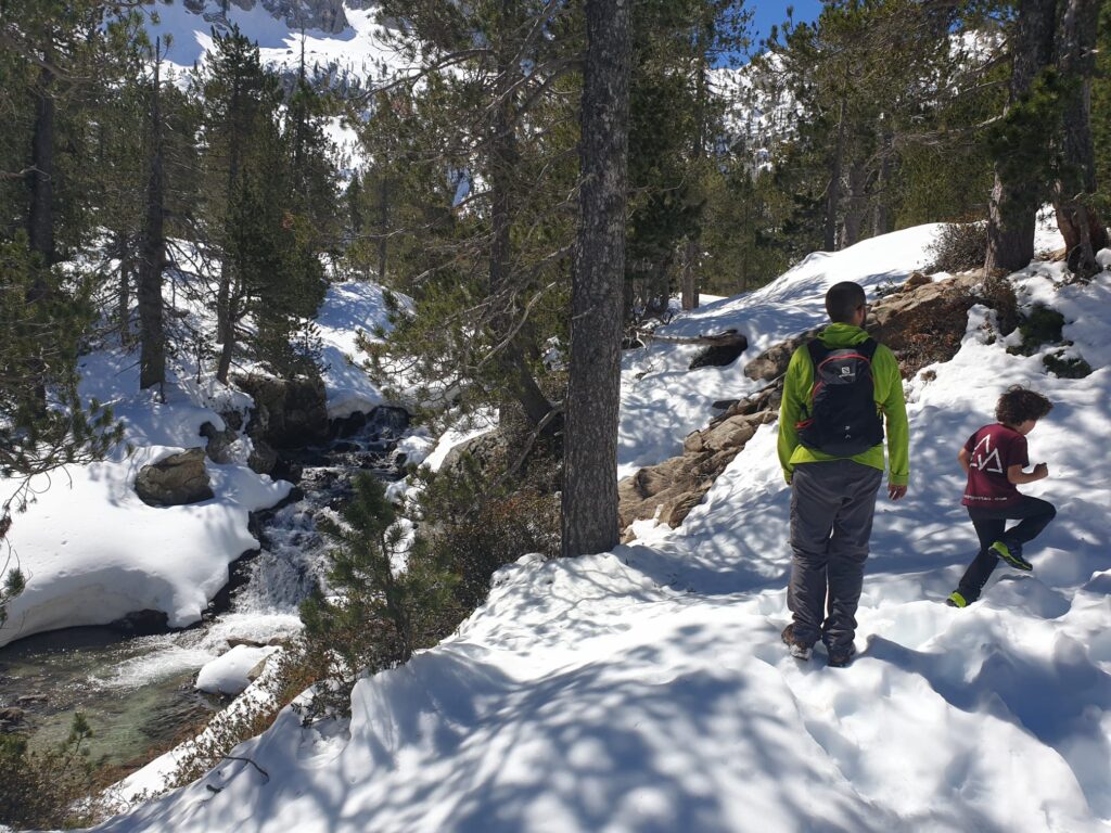 Familia haciendo senderismo en la nieve con ropa de abrigo