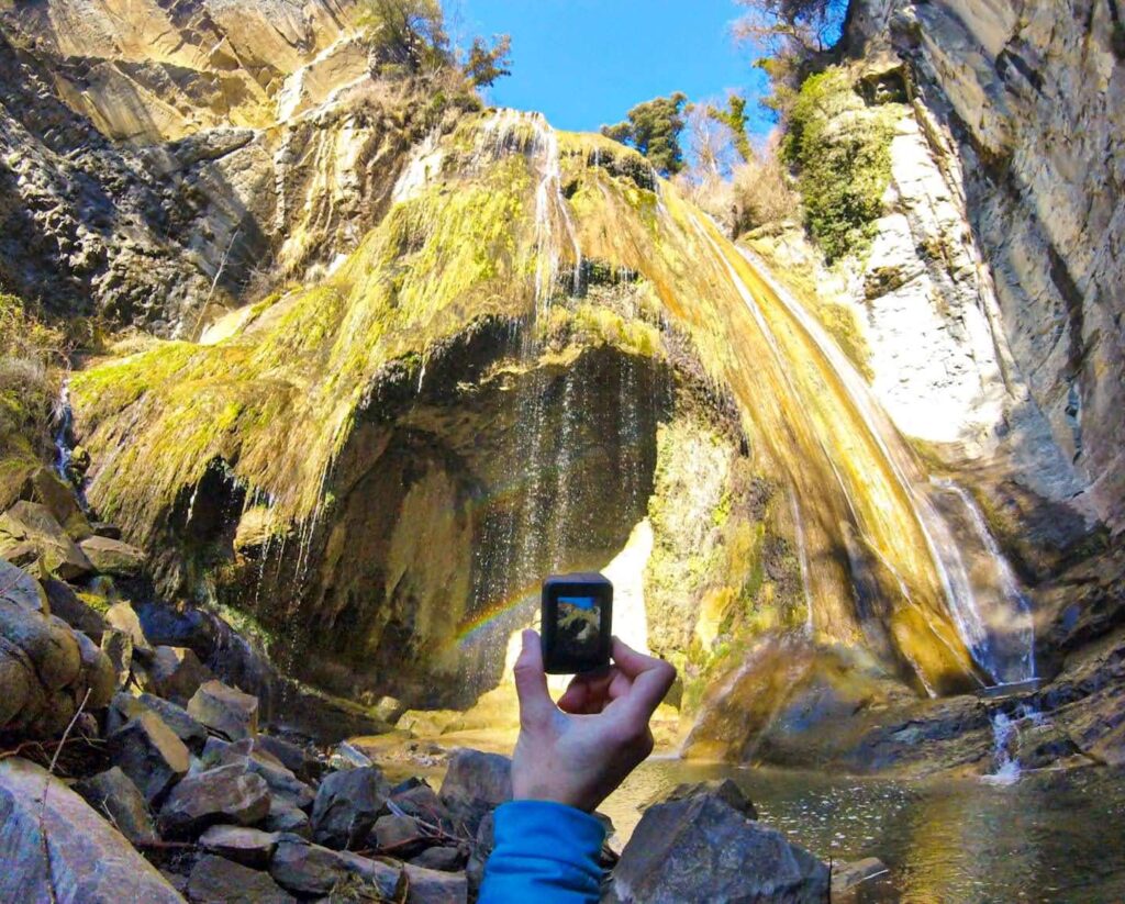GoPro fotografiando una cascada en ruta de senderismo con gran angular