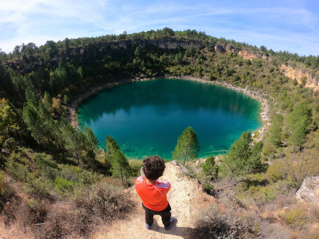 Niño asomado al borde de una de las lagunas de Cañada del Hoyo, Cuenca