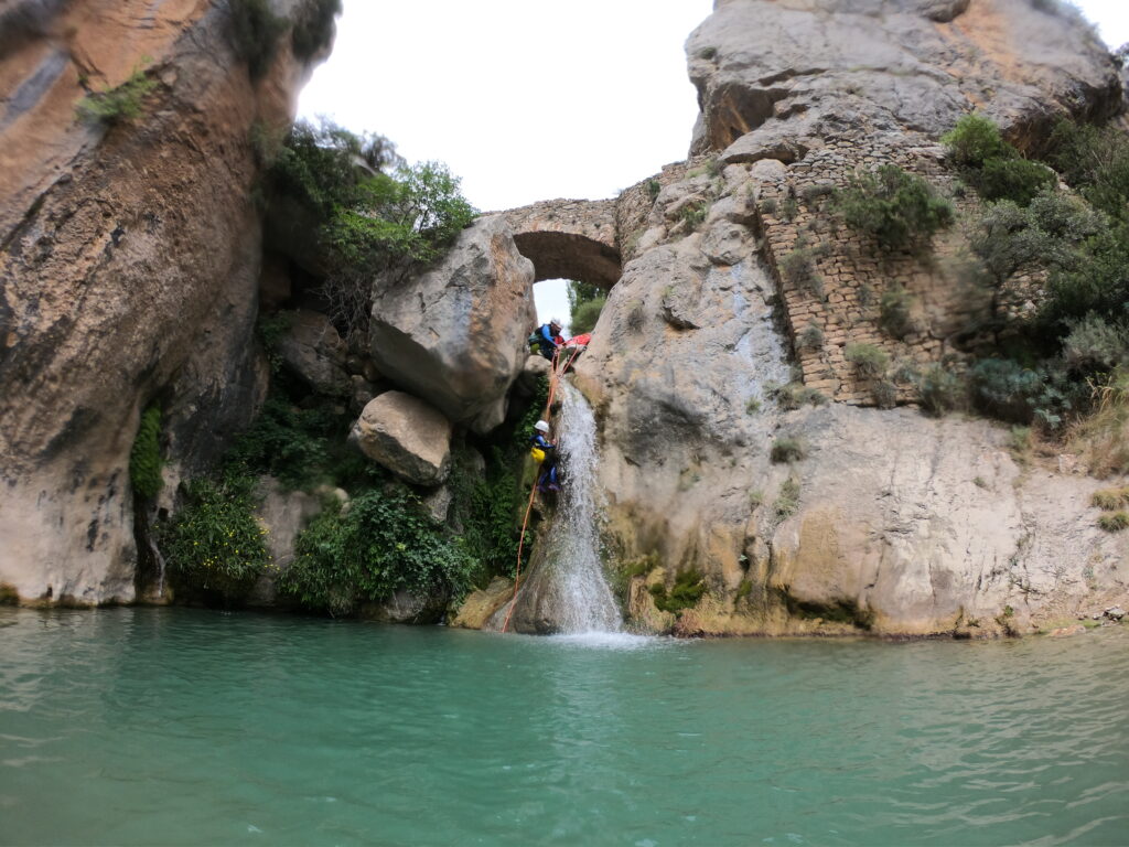 Rappel por la cascada de Bóixols bajo el puente medieval haciendo barranquismo
